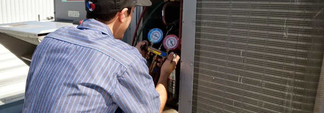HVAC technician servicing a condenser unit in Jesup