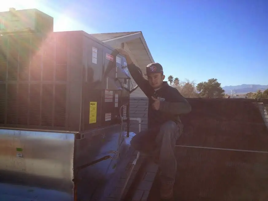 HVAC technician performing HVAC Inspection on a rooftop unit in Jesup